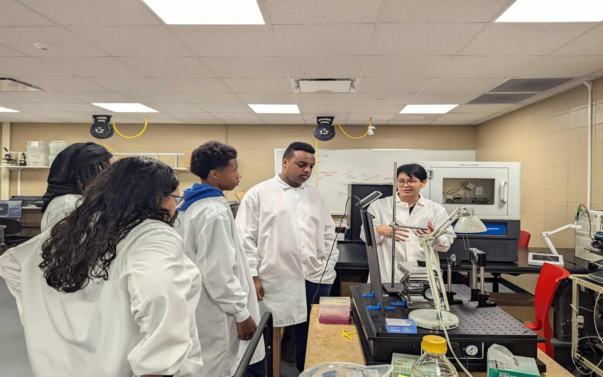 Innovative students in lab coats participate in STEM education at CPASS Foundation.
